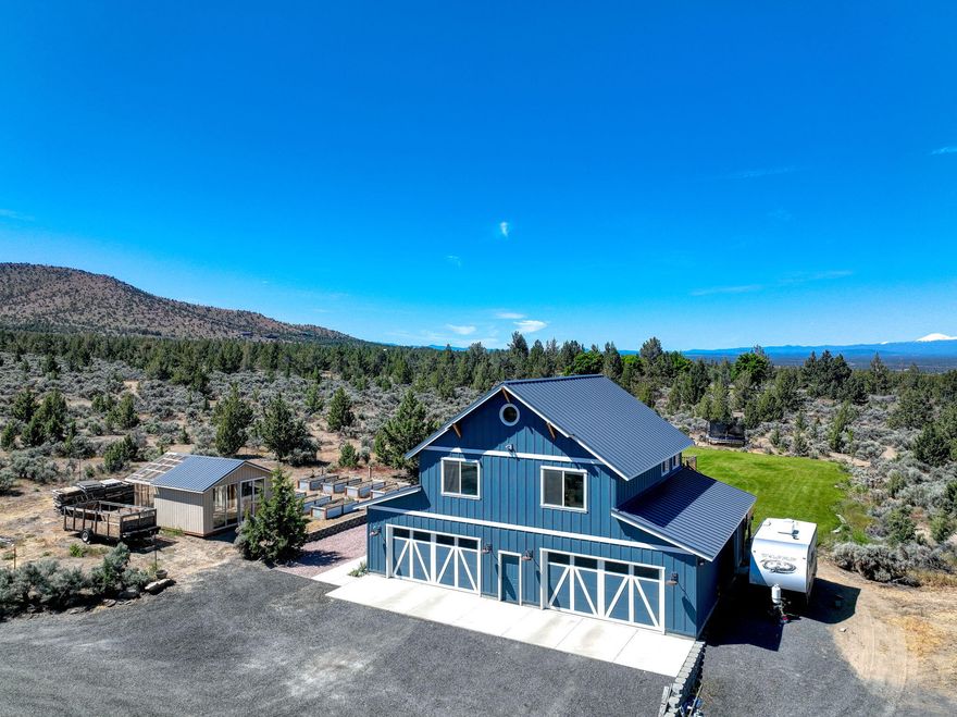7.81 acres of privacy and expansive mountain views from Bachelor to Smith Rock! Space to build your dream home while living in current custom home. Built in 2018, home offers 2 bdrms, 2 baths plus loft/bonus room & 4-6 car garage w/ 11 ft ceilings & half bath. Mid-level open floorplan features kitchen & great room w/ numerous windows, vaulted ceiling w/ fan. Sliding glass door opens to large 12 ft deep deck capturing exquisite sunsets & grass yard w/ sprinkler system. 8 raised garden beds w/ drip system & area for in-ground plants & small orchard with sprinklers. Three sheds; 16x20 greenhouse shed, 18x20 metal shed w/ roll-up door for hobby tractors or ATVs, & 10x20 wood shed w/loft for plenty of storage.
Seller had future plans to build addt'l home: septic system sized for up to 4 more bdrms. 40 gallons per minute shared well with 1 neighbor. No HOA or CC&Rs. Would be a great horse property too! *Back on market due to no fault of the Seller.