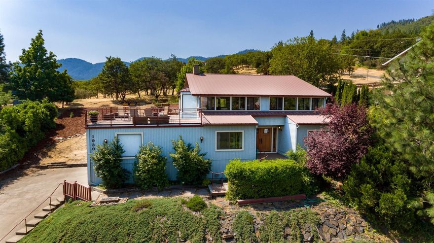 Situated on a peaceful cul-de-sac surrounded by nature and overlooking the Rogue Valley, this comfortable move-in ready home is located nearby Ashland's White Rabbit trailhead with access to miles of hiking. Panoramic views from Grizzly Peak to Table Rock, spectacular stargazing, and private outdoor entertaining opportunities await from two large deck areas. Versatile floorplan with energy efficient metal roof, adjustable air-flow damper system for heating & cooling, & wrap-around windows with electric blinds for natural light & wintertime warmth. Other features include Saltillo tiled flooring, vaulted exposed beam ceiling, 2 fireplaces, recessed lighting & large garage storage space. Kitchen is equipped with quartz countertops, stainless sink & tiled backsplash. The newly remodeled master bath is outfitted with travertine tile, radiant heated floors, & oiled bronze fixtures. Lower level with a separate exterior entrance, kitchenette, 3 bedrooms, & 2 full baths.