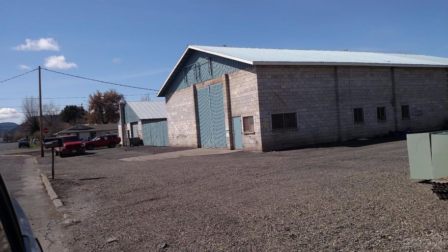 Sound concrete block building w/metal roof, off street parking, 3 phase electricity, natural gas, city water and sewer. Three overhead cranes in shop. Overhead boom crane in steel yard. Large wall mounted compressor. Building previously was a Machine Shop. Mezzanine perfect for storage and materials. Owner would consider trade.