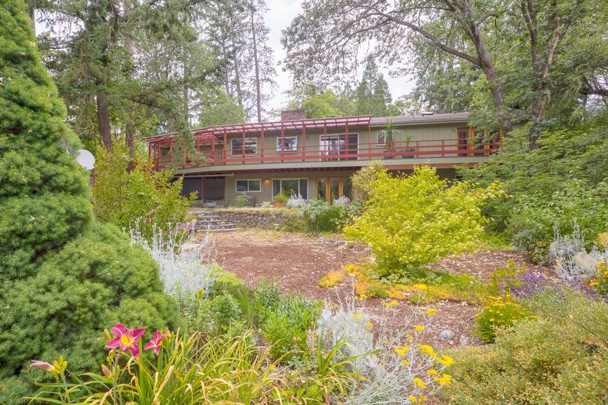 Discover timeless charm and modern comfort in this thoughtfully updated home. This spacious 4-bedroom, 3-bath residence offers 2,644 sq. ft. of inviting living space. The main level boasts 1,766 sq. ft., while the finished daylight basement adds 878 sq. ft. of flexibility. Hardwood floors, an abundance of natural light, and an updated kitchen create a bright, welcoming atmosphere. Step onto the expansive covered rear deck, stretching the length of the home, and soak in views of the lush flower and vegetable gardens cascading down to year-round Gilbert Creek, where you'll enjoy the sights and sounds of abundant wildlife. Nestled on .66 acres across two parcels, this serene retreat blends natural beauty with convenience. Don't miss this rare opportunity—schedule your private tour today!