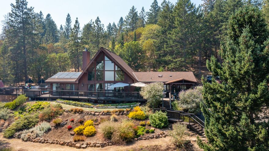 Beautiful cedar home, nestled in the trees, panoramic views, 5.58 acres. Seller's set up home w/3 bdrms, 2 Offices (bdrms?), Weight Rm (Movie Rm?), Game Rm, Drum/Music Rm. Flexible Floor Plan. Primary bedroom features amazing views, large bathroom, jetted tub & 2 large closets. Well-appointed kitchen w/Thermador & Subzero appliances, granite countertops, undercounter lighting, beverage cooler, insta hot water. Large loft w/stunning views. Multiple patio doors provide view, access to the 2000 sq ft deck. Hot tub, custom gazebo, solar heated saltwater pool, lighted portico w/waterfall feature, barn, tack room (sheds/shop?), raised growing boxes, fully fenced, gated & paved. Landscaping provides color & scents along various paths, dry creek bed, hillsides & waterfall. Lifetime Warranty Comp Roof. 400 AMP service, generator wired home. 2015 well flow test 13gpm. Electric Water Heater, Propane Water Heater, 2 Heat Pumps plus 1 split A/C. How Would You Set Up This One-of-a-Kind Masterpiece?