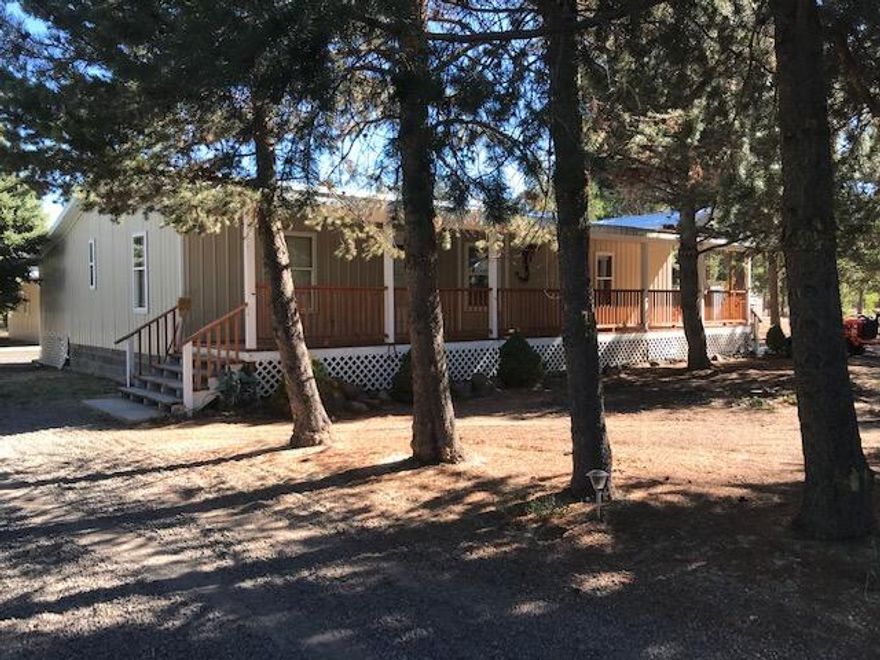 Huge Price Reduction! Nestled in the pines, this private home has a beautifully updated kitchen and  includes a pantry & laundry area. Wood and tile flooring with carpet in bdrms.  Primary bdrm has remodeled en suite w/both tub and separate shower. All bedrooms have ceiling fans & lighted walk in closets. Spacious Living Room w/Bay Window & ceiling fan overlooks forested front yard and full covered deck. Full back deck w/heated  storage/canning room.  12 x 28 RV Ramada with hookup. Don't miss the amazing detached garage/shop. Can easily hold 3 vehicles with room to move around or turn into a wonderful shop. 16' lean to on the back for tractor/equipment/toy storage and a metal storage shed with shelving complete the outbuildings. Chicken coop has electricity. Circular drive, gated entry, fully fenced and a back gate to Old Cabin Rd. and acres of public land, bring your ATV. Can be financed w/Mid Oregon CU, Jenny Vessey or a 203k rehab loan for a few minor repairs. Call LA for details.