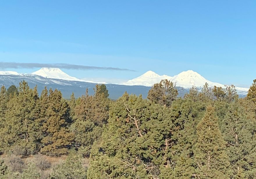 Hidden away in quiet Lovestone Acres is a custom gem that sits high on a hill with unobstructed views of 7 peaks and not a house in sight! Beautiful big windows let the mountains and outside living areas in.  Thoughtful detail throughout the home with tile floors, granite counters& stainless-steel appliances Remote controlled solar shades on most of the windows. The main floor with living room, dining area, and kitchen all take in the incredible views and outside living area. Down the hallway is the primary bedroom and bath with jacuzzi tub and walk-in shower. 2 other bedrooms, a guest bath, and laundry complete that floor. Upstairs is another large bedroom, guest bath and bonus room with deck. Then there is the 34x36 insulated shop with 2 10ft doors and a 14 ft. door. Complete RV hookups complete this lower area. Tuck away within minutes to Bend, Redmond, and Sisters.  This is a unique magical one of kind property. Welcome Home! Seller will consider carrying the contract.