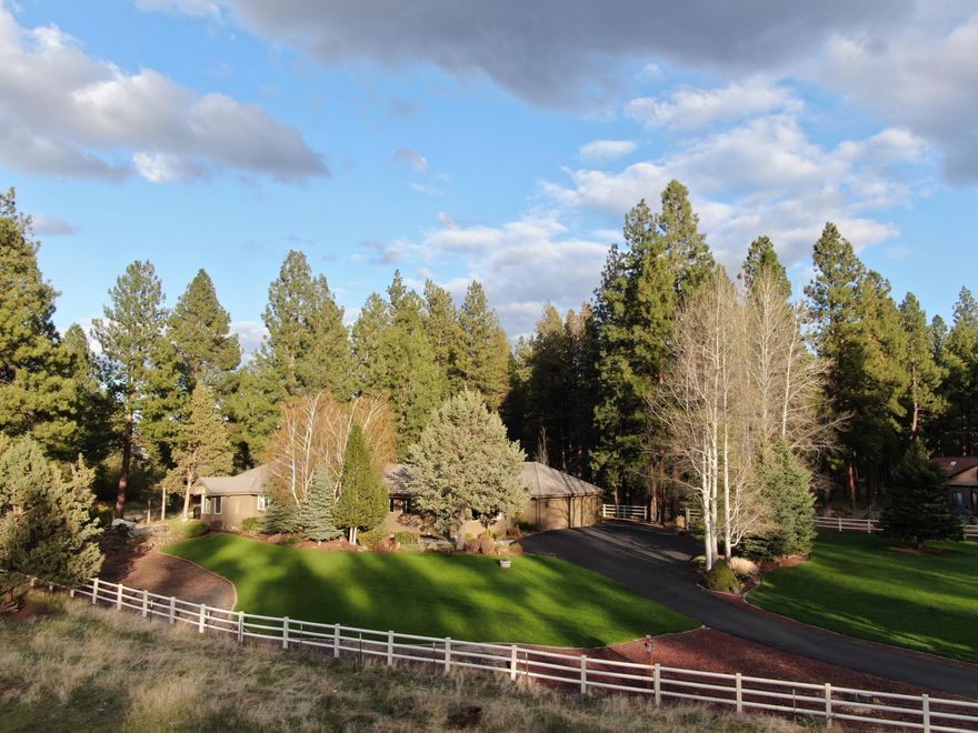 Gorgeous mature landscaping surrounds this  immaculately cared for 3057 sqft home. 3 bedrooms, an office, a separate craft room, and two gathering spaces, one with a propane fireplace and one with a wood stove, are highlights of this single level property! With only one neighboring home, the preserve behind the home, meadow and pasture to the North, the Deschutes National Forest across the street provides privacy while you still live close to town! The heated woodworking shop, fenced garden area with raised beds, waterfall and creek, full RV connections and detached studio with half bath, round out this singular opportunity in Sage Meadow!