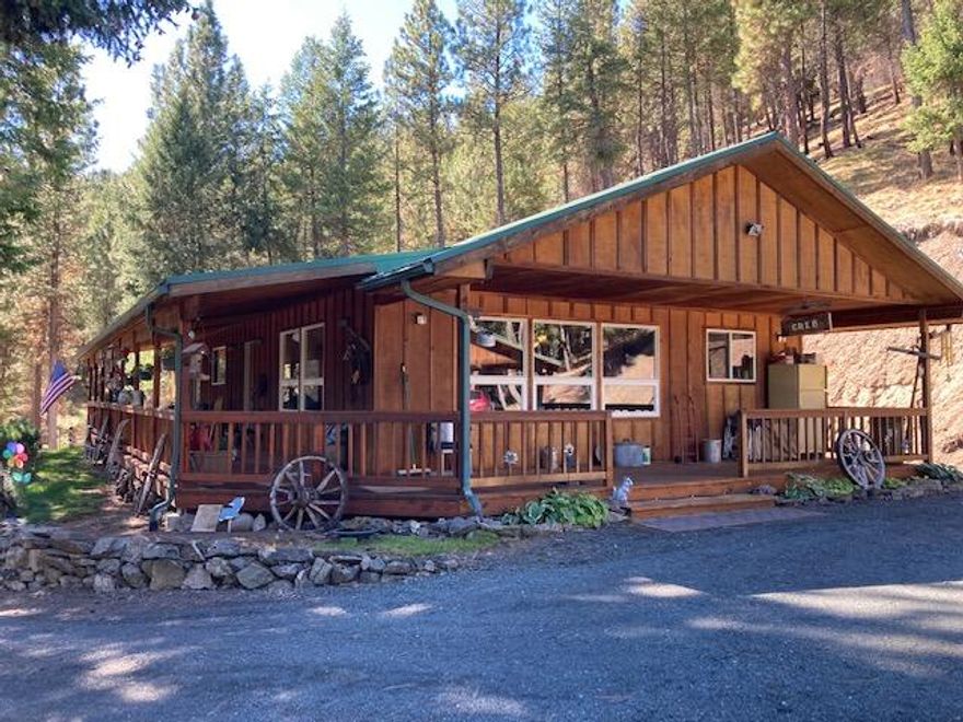 34 Timbered Acres w/Picturesque Mt Views! Wood sided custom home, peaceful and private setting, open floor plan w/vaulted ceiling, kitchen features Oak cabinets w/Quartz countertops, appliances & new flooring, living room features view windows overlooking the pine trees, ceiling fan & wood stove, utility room, 3 bedroom, 2 bath, master w/double sink vanity & a walk in shower, carpet, laminate & vinyl flooring, forced air electric furnace, insulated walls, vinyl windows, metal roof w/gutters, covered decks on two sides, landscaped w/drip system, extremely large graveled carport has space for 9 vehicles, large insulated shop w/cement floor, sheet rocked, overhead doors on both ends & a man door, lean to attached to shop for RV parking, frost free faucets, both home and shop are wired for generator usage, RV dump & hook up.  $549,000 #1061