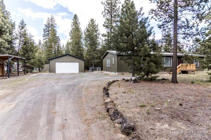 Immaculate home on forested acre lot that is completely fenced & has 2 large privacy gates. Recent improvements to the home include exterior & interior paint(2014); carpeting(2014); refrigerator & range/oven(2013); kitchen sink(2014); dining room fixture(2014); new front & back decks(2014); solid wood fence entire length of north boundary. 24x36 detached garage has room to park 4 vehicles. There is also a detached 2-bay carport & a separate 200 sq ft shop. Newberry Estates borders the National Forest.
