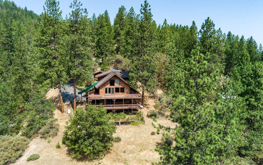 Priced to sell! Highly sought after location on Tami Ln in the West Hills close to Jacksonville. Valley Views, paved & gated entry w/ 4 car garage. Lg decks on main level & downstairs level. Amazing for entertaining. Lg vaulted & open beam ceilings, 4'' thick cedar walls & siding. Lg primary suite w/balcony, walk in closet + 2 other closets. Dbl sinks & lg shower. Loft off primary suite would be a great office w/ views towards Jacksonville & mountains & Lg evergreens. Kitchen w/ lots of cabinets, island w/downdraft propane cooktop that opens to breakfast area & living rm. Formal dining rm w/built in bookcases. Family rm downstairs in daylight basement w/half bath & laundry rm. Slider to lg deck. Home offers lots of potential to make it your own. Hardwood & laminate floors throughout the home.