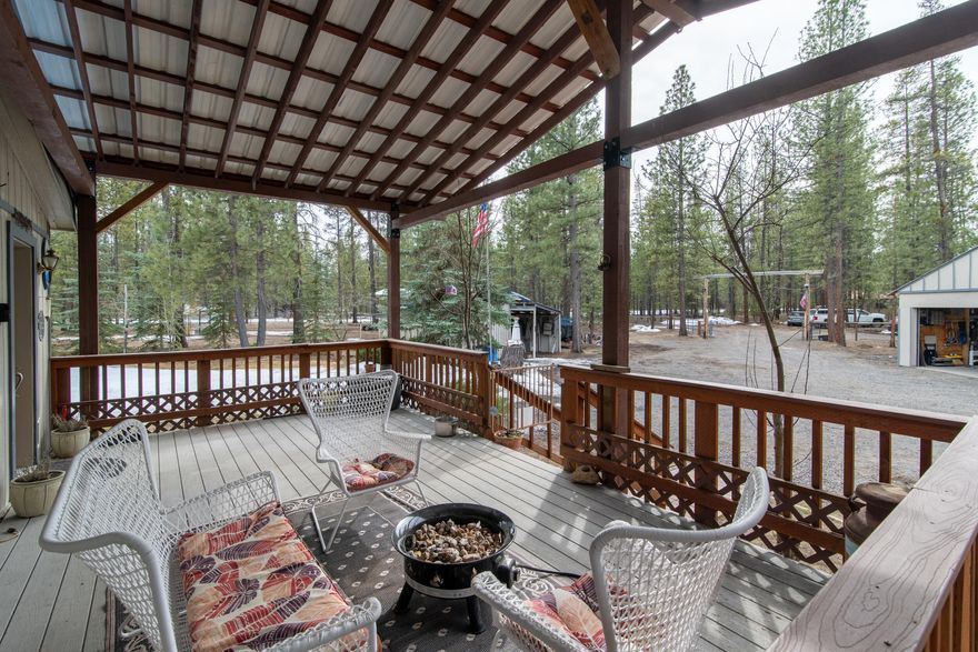 Seller offering 10k for buyers rate buy down! If you're looking for privacy, adventure and room to spread out, this place has it all! Tucked away on a quiet dead end road with access to miles of trails, this 5 ac wooded property is surrounded by tall ponderosas and plenty of wildlife. The 3bed/2bath has 1296 sq ft of living space with an open kitchen that into the dining and family room. Recent updates include new appliances, flooring and fresh touches in the kitchen entry and baths. Outside you'll love relaxing on the huge covered deck perfect for summer nights or sitting around the fire pit area when it gets chilly. There's plenty of space for all your hobbies and storage needs including a large shop for projects and toys, covered RV storage with hookup wood working shop, chicken coop, greenhouse, and a bonus 1200 hobby cabin previously used for guests. If you want room to roam and a peaceful setting to call home this is the spot for you!