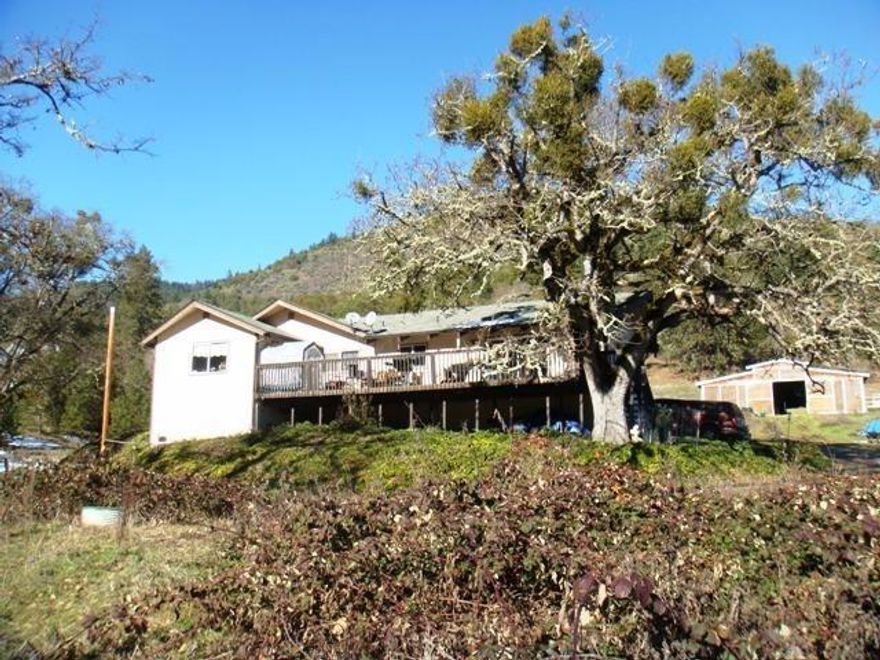 Bring your horses and farm animals to this great Applegate property and enjoy the Views, Views, Views! Solid home with open floor plan, vaulted ceilings, and beautiful wood burning rock fireplace. Large deck and room to entertain. Gorgeous views of the valley and surrounding mountains from every room. 8 stall barn plus additional area for animals and pasture. Usable, rolling land only 10 minutes to Ruch in the sunny Applegate.