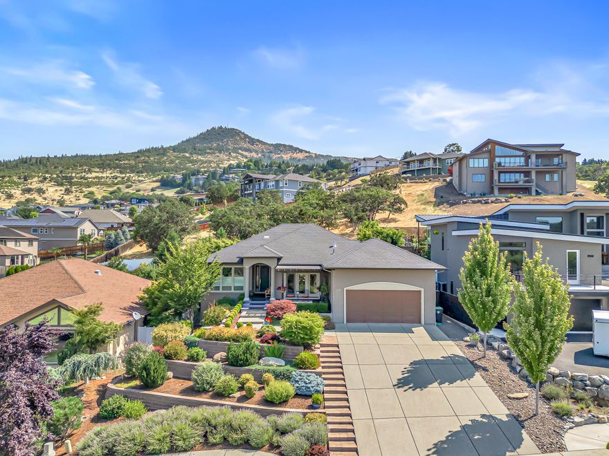 Stunning, single-level Vista Pointe 3BD/2.5BA + office in the East Medford foothills of Roxy Ann! Sweeping valley views here to stay, as home faces Oregon Hills Park greenspace to the SW. Thoughtfully designed indoor & outdoor spaces offer tasteful custom finishes, privacy, and a tranquility only felt in person. Enjoy morning and evening meals w/ever-changing sunrise & sunset backdrops from the elevated front patio or the cozy dining room. Chef's island kitchen w/Wolf 5-burner range, Electrolux oven, granite counters, extensive cabinetry & bar pass-through. Central, airy living room features 10'5'' ceilings, corner gas fireplace w/floor-to-ceiling stone surround, open views to backyard & access to covered patio. Split floor plan offers separation for the two primary suites! Larger suite w/travertine tile shower, heated floors, dual vanity & walk-in closet sized for two. Office & third bedroom have great natural light. Yards masterfully landscaped for aesthetic beauty at every glance!
