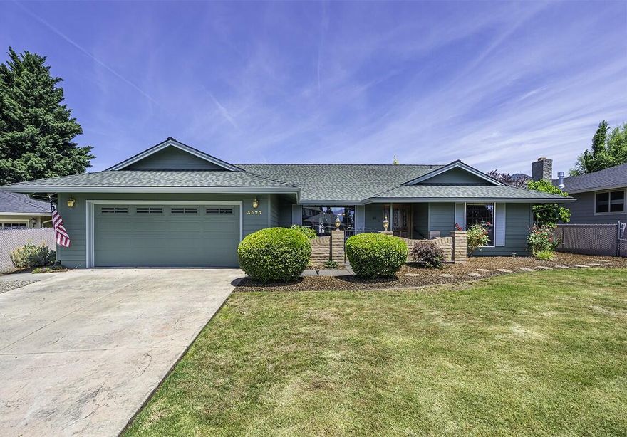 Charming, single level 3 bed, 2.5 bath home perfectly placed within minutes of schools, shopping, golf and Rogue Regional Medical Center! Updates and features throughout including hardwood floors in the main living areas, multiple spaces for living and dining and a dedicated laundry/mud room with built-in cabinetry. Convenient kitchen equipped with ss appliances, breakfast bar, granite countertops, unique pass-through feature & tile floor. The cozy family room features a gas insert fireplace framed by brick surround and classic wood mantle. It connects directly with the kitchen and back patio, perfect for entertaining. Spacious primary suite with private patio access and ensuite boasting tile floors, a dual-sink vanity & linen closet. The fully fenced yard includes mature, low maintenance landscaping, raised garden beds, storage shed & side yard. 2-car garage with built-in storage & EV hookup. Don't miss this fantastic property!