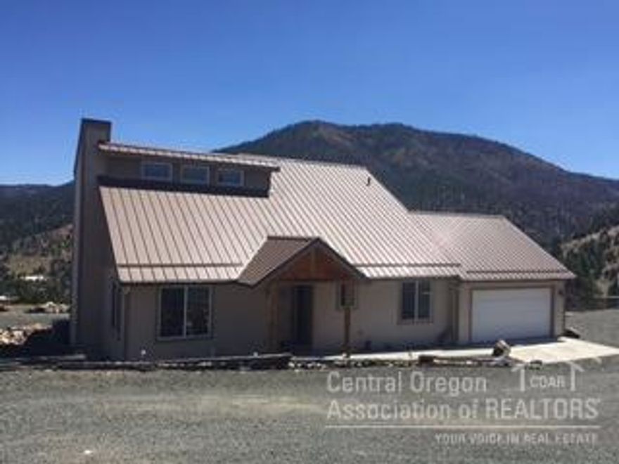 Beautiful 2 Story Home On 1.34 Acres! Custom built home w/outstanding Canyon Mt & valley views, vaulted ceilings, open floor plan, 1586 sq ft, 3 bed, master w/French doors onto Trex deck, 2 bath, kitchen w/Hickory Cabinets & stainless steel appliances, dining area, lots of storage, tile, carpet & laminate flooring, heat pump w/AC, wood stove w/tiled hearth, metal roof, septic, new well, attached insulated double car garage, gravel driveway, 30 x 36 metal shop w/concrete floor & 220 service.$260,000 #897