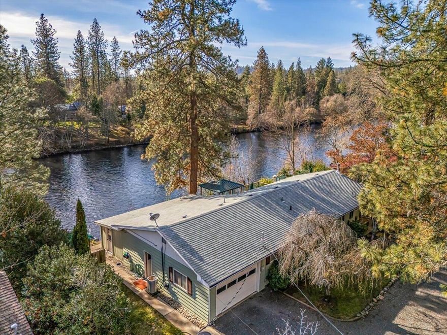 Discover the best of riverfront living with this quaint and classic 2-bedroom, 2-bathroom home featuring 100 ft of Rogue River frontage, a large entertainment-ready deck, and breathtaking river views from inside the home. Enjoy added lifestyle bonuses including a private dock on the river, perfect for fishing, launching a raft, or simply relaxing at the water's edge. This property is packed with value—water rights, an irrigated and fully fenced garden area, and a small shop ideal for storage or projects. Inside, experience a warm, inviting atmosphere highlighted by a cozy wood stove, abundant natural light, and a practical layout designed for comfort. A high-quality water treatment system ensures clean, great-tasting water throughout the home, and the hot-tub-ready setup by the back deck offers stunning river views.