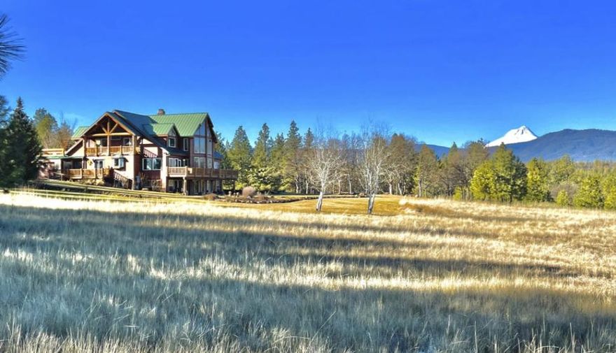 An incredible offering, this special, irrigated 75-acre estate, backing to hundreds of thousands of acres of public land, includes a main lodge, guest house, small creek, fishing pond, and outbuildings.  Five Arrows has stunning views from the 6,147 square foot main lodge overlooking meadows and oak prairie.  The view from the floor-to-ceiling two-story windows seamlessly blends the home and natural world with its impeccable craftsmanship and layout.   Nature abounds with deer, elk, wild turkey, waterfowl and geese that come into the two-acre trout and bass-filled pond or to feed in the native grass meadows. Consisting of two separate and adjoining tax lots, the main lodge, ancillary structures, and two-acre pond are all located on the 65-acre parcel. The 800 square foot potential guest home or office is on an adjoining ten-acre tax lot but is totally self-contained with water rights, power, and on a shared well with the main lodge.