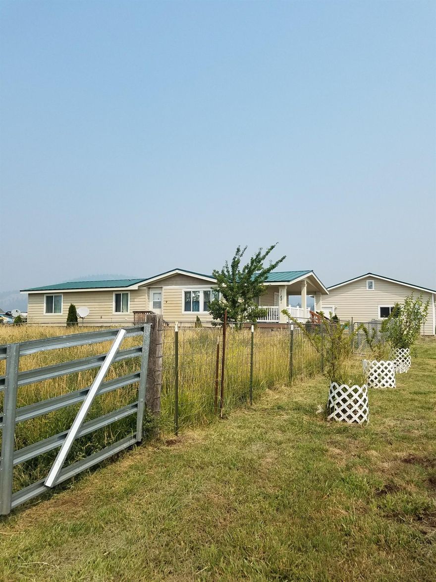 Looking for country living? 5.94 irrigated acres. 2006 Marlette Manufactured home, 3 bedroom, 2 bath. Open floor plan, large kitchen, Acacia laminate floors throughout main living area. Big Utility room with enclosed back porch, covered deck, fenced yard. 28x32 garage. Pole barn with power and water, set up for cows, 2 covered RV ports. Must See!