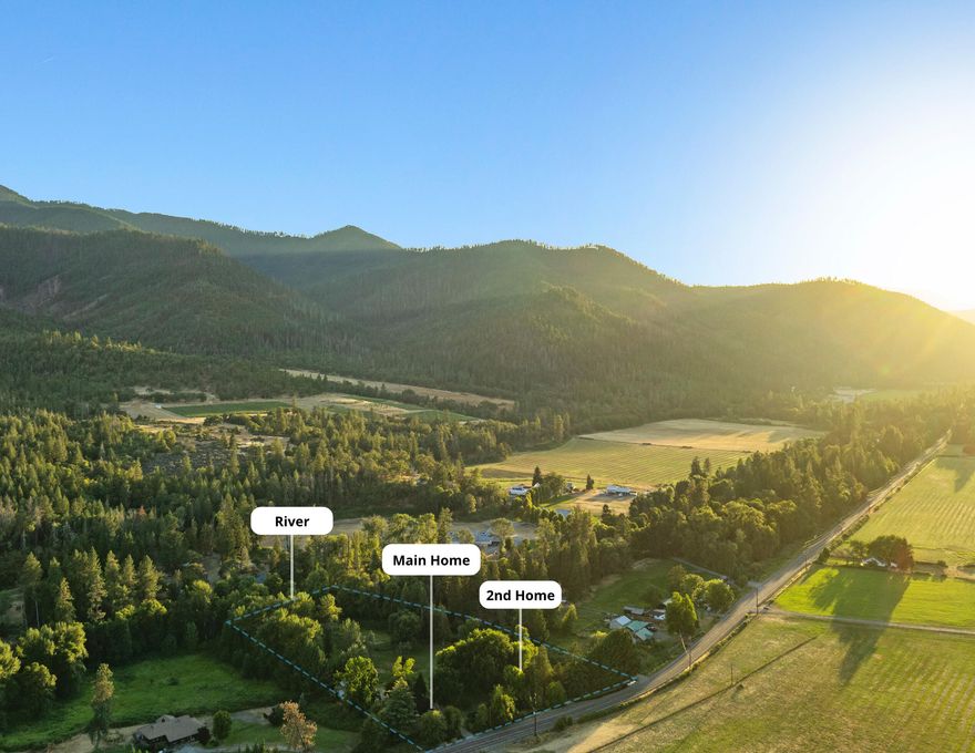 Set on 4.55± acres along the Applegate River, this park-like retreat features level lawns framed by mature trees, small pond, & +/-200 feet of river frontage - an inviting backdrop for gatherings, relaxation, & time on the water. Two legal homes, barn, & chicken coop blend lifestyle charm w/utility. The updated main home (~2,024 SF) comes fully furnished & offers a vaulted great room w/exposed beams, & newly remodeled kitchen w/large island, abundant counter space, & sleek, modern design. Three bedrooms & three baths are complemented by a versatile bonus sleeping/game room. Outdoor living is private w/a large deck, patio, & hot tub overlooking the lawns that stretch to the river. A detached two-car garage sits beside the home. The second home (~1,147 SF) features vaulted ceilings, an eat-in kitchen w/pantry & built-ins, two bedrooms, 1.5 baths (main w/separate soaking tub & shower), a two-car attached garage, & a covered deck. Minutes to Red Lily Vineyards & close to Jacksonville.