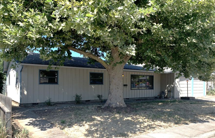 Here it is! A 3 bed 2 bath home with possible ADU on a large lot in Central Point! There is original hardwood flooring throughout most of the home and a brick fireplace in the living room. The first bedroom down the hall is set up with counter space and shelving for a possible workspace. Take note of the beautiful wood doors on all of the bedrooms. The glass double doors take you to the covered patio overlooking the large backyard.  You will find a large laundry room off of the kitchen with ample space for storage and an extra half bath. The extra room in the garage was a professional darkroom for photography but would be great for extra storage or a hobby room. In the backyard you will find a building that could possibly be an ADU and a quonset hut with shelving for even more storage. Mature shade tree, new gutters, some fresh paint, and irrigation in the front yard. Move in, get organized, and make this home your own!