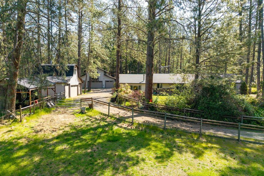 SHOPS!!! 10.3 beautiful acres, tall pines & lush green meadows only 15 minutes from GP!  This amazing property features a 2729 SF home with long range views, 3 BR, 3 bathrooms, living, family & great rooms, large laundry area/mud room opens to the spacious new deck. The kitchen has maple cabinets galore, granite counters, walk-in pantry & eating counter for 4.   The large gas generator plus 2 garage/shops with 9 access spaces are an added bonus.  Shop Bldg 1: 40 x 40 shop/garage with 5 bays (4 in front, 1 bay at side) with large, finished 4th ''bedroom'' plus bonus space above, with a true shop inside on the lower level.  Garage Bldg 2 is a 4 car garage w/finished bonus space above. 2 tax lots of 4.3 & 6 acres. The fenced/cross-fenced acreage also boasts 2 great producing wells, in-ground sprinklers, 2 large seasonal ponds with driveway between for additional property access. There is a large, fenced garden area plus pasture, 2 stalls, feeding troughs & concrete watering pools.