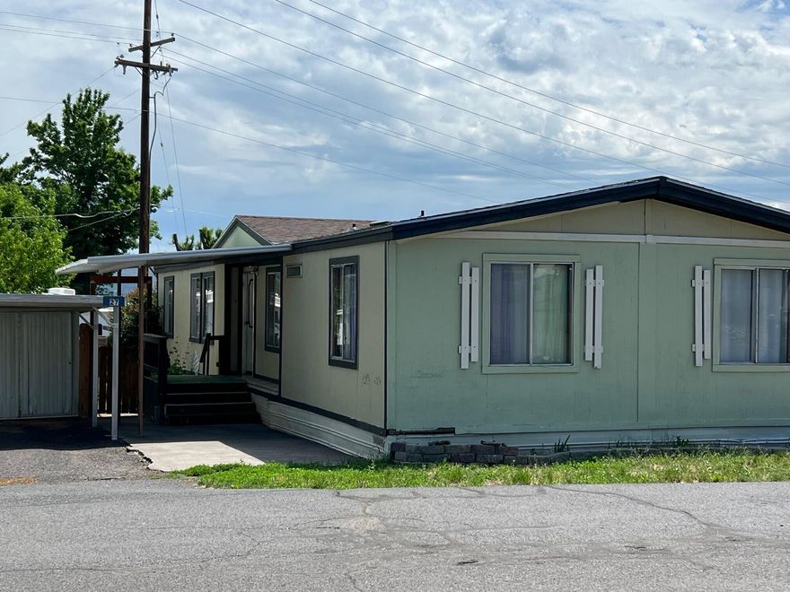 Nice three bedroom, two bath manufactured home in a clean and quiet family-friendly park.  This home sits on a nice sized lot and is in good condition for its age. The roof is approximately 10 years old and the laminate flooring throughout has been replaced within the last five years. This has a very nice floorplan with primary bedroom and bathroom on one end and two other bedrooms and bathroom on the other end with kitchen, dining, and living room in the middle plus a large laundry-mudroom are. The kitchen is spacious and has a newer convection oven and electric stove top. The outside has some nice features...a mature fruit tree and berry bushes, a nice deck for added entertainment and outdoor relaxation/enjoyment, a carport with storage shed and a larger shed in the back with shelving. This unit is in a cul-de-sac location with visitor parking directly across the street.