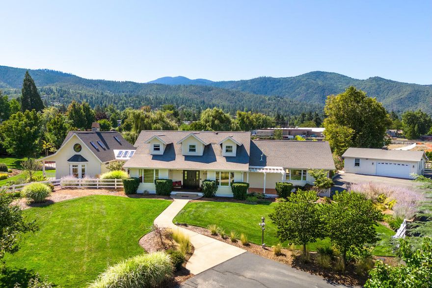 Resort-style living in beautiful Ashland, Oregon. Two lushly landscaped acres just outside city limits provide the perfect place for the family seeking a balanced life. The gracious Cape Codstyle house has abundant windows, wood and natural stone that give the interior a sunny and relaxed Pacific Northwest vibe. Artistic custom touches will surprise and delight: look for the mermaid! The primary bedroom wing will become your private retreat, with stone fireplace, loft and spa-like bathroom with gorgeous mosaic tilework. Outside, a spectacular pool with kitchen and stone fireplace invite family fun and informal entertaining. The home wellness
center has an exercise room, steam bath, sauna, and a light-filled studio. An in-ground trampoline, pickleball court and fully equipped media room add to the resort feel. Whether you're looking for a special home for an active family, a sanctuary to rejuvenate and relax or a showplace for entertaining, you'll find it here. Ask for feature list.
