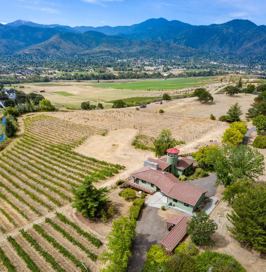 Stunning 6.94-acre property with sweeping views of Ashland, Pilot Rock, and Mt Ashland. Custom built 2357 sf home filled with n atural light, tile roof, spacious rooms and floor to ceiling windows. Vaulted ceilings, island kitchen and hardwood floors set the perfect stage for bringing your vision to this unique home in a very special setting. 5.3 ac of TID irrigation, 4.5 ac of them vineyard; planted in 7 varieties not currently in use, allows you to restart production or use the irrigated land for whatever suits your fancy. Downstairs family room with sliding door out to the grounds and vineyard/ Detached 500 SF studio with vaulted ceilings, loft, full bath and kitchenette also takes advantage of the stunning views. Located in Ashland's East hills, this property is surrounded by large custom homes and boasts a shop, 2 car garage and outbuildings for your equipment and toys. Don't miss your opportunity to live on this exceptional property just mins to all that Ashland has to offer.