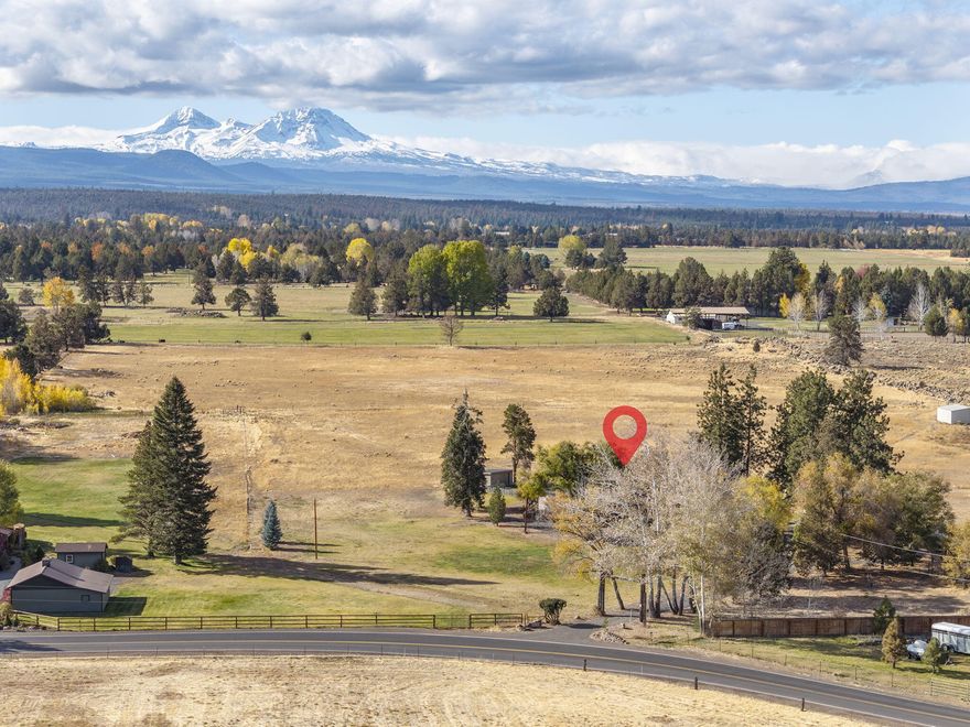 Discover 58.55 acres in the heart of Tumalo, where sweeping Cascade Mountain views set the backdrop for endless possibilities. Whether your vision is an expansive private estate, a premier equestrian facility, or productive farmland, this exceptional property offers a remarkable canvas. Currently home to a hunting dog operation, the land features 39.21 acres of TID irrigation (portion in in-stream lease), open pastures, and garden areas. The single-level 3,016 sq. ft. residence showcases a great room concept, an updated kitchen with granite counters and custom cabinetry, and a primary suite with office, private view deck, and spacious bath with walk-in closet. Two additional ensuite bedrooms. Property amenities include a heated and plumbed dog kennel, outbuilding, and multiple run-in/storage sheds. With three tax parcels and EFU zoning, this is an extraordinary opportunity to create your dream property in a highly sought-after Tumalo location.