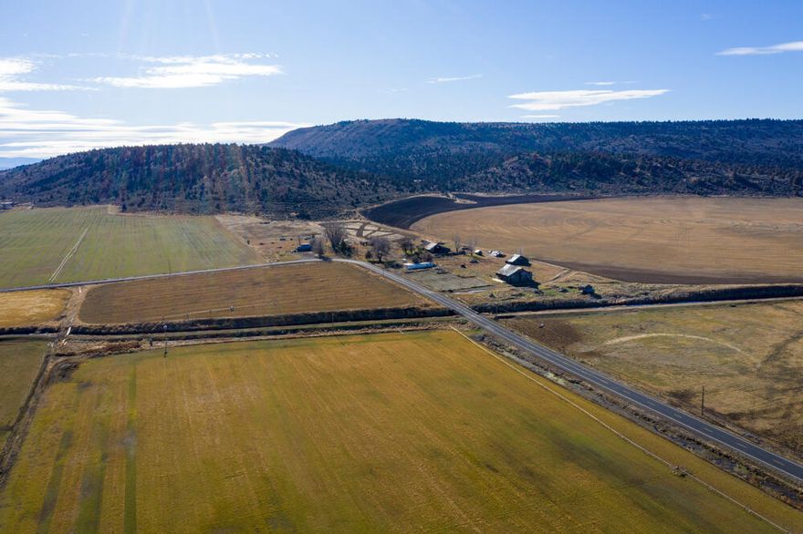 This property has a mix of irrigated farm ground 201.4 irrigated and 1,188.57 acres Forest Range. There  are wheel lines, pack line and main line & pump included in sale. The Pivot belongs to Tenant. Property has a well water right dated 1957 and Supplemental water right dated 1965 for 94.6 acres This well has been relocated and Drilled by Chancler Drilling completed May 2022. Pump & Power still need to be completed. There are KID 40.6 & KBID 66  = 106.6 acres. There are Hay Barns & Shop on property in dated condition. The manufactured home is dry storage only. Buildings have been given no value.