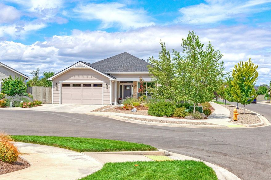 Prime location in the desirable Stonegate Estates! This single level home is spacious at 1869 SF w/ an open floor plan & filled with light! Large 0.20 corner lot offers privacy & adjacent to the walking path. Charming covered front porch. 2 of the bedrooms are located off the entrance w/ a full bathroom conveniently situated. The living space has raised ceilings, engineered oak floors & looks out the large windows & patio door to the back yard. The living room has a gas fireplace & TV nook wall space. The kitchen has a large island for entertaining, granite counter tops, walk-in pantry & quality painted cabinets. Stainless appliances & functional coffee bar area. The dining area is perfectly located off the island. The primary bedroom has vaulted ceilings, custom blackout shades & quality fixtures. Attached bath w/ tiled shower & double sink opens to the walk-in closet. Back yard was extensively upgraded w/ professional landscape, pavers for the sitting area & trellises for privacy.