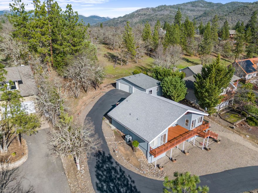 Wake up to some of the best views of the Rogue River! This idyllic retreat sits on half an acre with a fully paved driveway which was recently seal coated! The home encapsulates tons of natural light, featuring vaulted ceilings and huge open living room windows that frame the breathtaking scenery. With an open designed split-floor plan, this 3-bedroom, 2-bath haven also features a versatile loft, a large partially finished basement (1,000+SQFT) which would be perfect for an ADU or extra living space, and a detached 4-car shop/garage! Additional amenities include RV parking, a covered patio for entertainment, a centrally located breakfast bar, and a cozy wood-burning fireplace. This property is on city water & sewer. The Roof, HVAC, and Water heater are all in great shape!