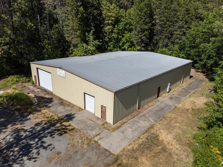 This industrial zoned property offers a unique combination of rail access, infrastructure, and acreage with close proximity to I-5 at the midpoint between Grants Pass and Roseburg. Situated on 6.87 acres, the site includes an 8,000 SF steel-framed warehouse built in 1987, featuring 20-foot clear height, two roll-up doors, and a second rail-slide door. The building is ideally suited for heavy equipment use, fabrication, logistics, or ag-based processing. The property is fully fenced and gated, with gently sloped topography that supports future expansion or outdoor storage. Water is supplied by an on-site private well and is further bolstered by up to 1,665 gallons per day from a shared neighboring well—ideal for users with production or irrigation needs. This is a rare opportunity to acquire a property with rail adjacency, land area, and flexible zoning in Josephine County.