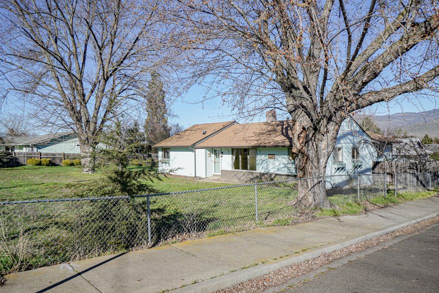 Large 4 bedroom ranch style home in sought after South Talent location. .34/ acre corner lot with Talent Irrigation District water. Large rooms throughout including master bedroom and bath, central kitchen, central gas heat plus  fireplace, vinyl planking floors, massive living room plus den, separate laundry, mudroom, large deck with vistas of Grizzly Peak, garden area and some fruit trees. Possibly room for an accessory dwelling unit ( check with the City of Talent Community Development office).