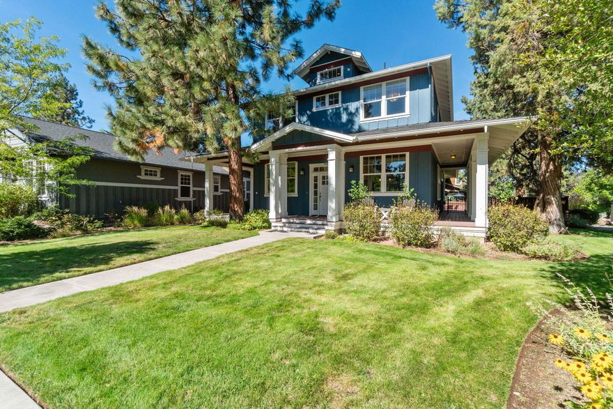 This beautifully crafted home by Gary Laursen boasts a large wrap-around porch facing south, with abundant windows that fill the space with natural light. The stunning entryway features coffered, wood-inlaid ceilings above elegant stone and hardwood floors. Double glass doors lead to an office, currently used as a TV room, with a striking coffered, lighted ceiling. The main living area is open and airy, with a gas fireplace framed in stone tile. The well-appointed kitchen offers ample storage, solid wood cabinetry, and an efficient pantry. The oversized primary bedroom includes a spacious, shelf-lined walk-in closet, with a luxurious en suite featuring a tile-surround corner soaking tub and glass-enclosed shower. Two more large bedrooms and a full bath complete the second level. The fully fenced backyard offers relaxation on the covered deck or paver patio. An oversized, attached two-car garage provides plenty of room for vehicles and storage, making this home a perfect retreat.