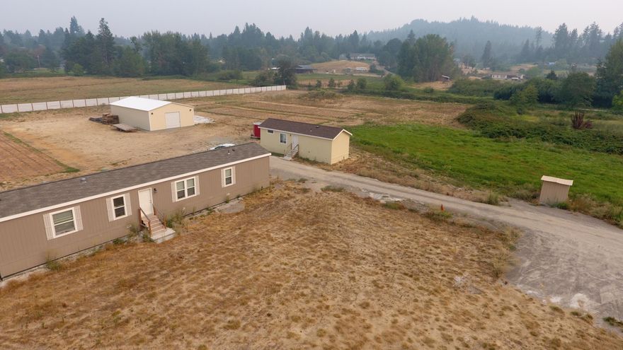 Here is a great location for your hobby farm or next productive agricultural endeavor.  
5 sunny, flat, privacy fenced acres with water rights from Grants Pass irrigation district.
Enjoy your own pond and views of the hills around the valley in a neighboorhood of farms and large lots.
There are two 2018 mobile homes, one is 1080 Sq Ft the other is 560 Sq Ft.  
There's a new 50x30 metal building. There's 400 amps of power available.
75 GPM well.
Motivated seller bring your offers!