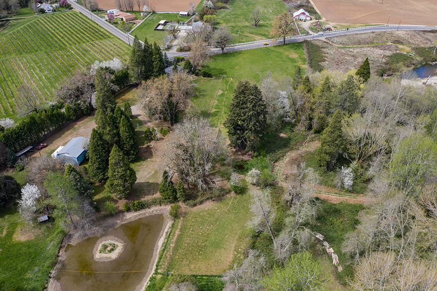 Highly desirable Exclusive Farm Zoning, 4 legal, separately buildable tax lots; over 5 acres, fenced, gated & extremely private with so much to offer; walking distance close to County land w/ Year-Round Sucker Creek; this property has a very nice 1755 s/f 3 bed, 2 bath home w/large covered back deck overlooking nutrient rich pasture (stays green), a 2nd established homesite (single-wide just recently pulled out) overlooking year round pond, established fruit trees, a 30x40x14 RV/Barn/Metal Shop, cross fenced pasture w/a large 60x26 garden w/ coop, power & water, in a truly park-like setting between established blueberry farm & Bridgeview Winery on Holland Loop, a scenic & historical (original settlements) country road 4 miles from the town of Cave Junction & 30 miles from Grants Pass. Huge Western Red Cedar & Oak trees, well-groomed grounds. Trails, streams & pools, abundant wildlife.  50 gpm well per log. Water Rights – Buyer to Do Due Diligence for Viability. Appt Only.