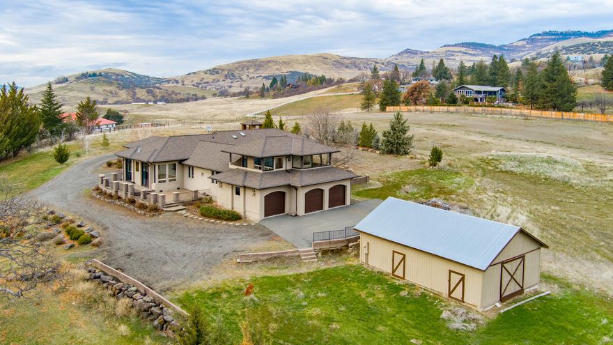 A gorgeous country setting surrounded by incredible views in all directions sits this spacious Prairie-style home on a gently rolling five-acre lot with T.I.D. irrigation. Circular drive w/ Porte-cochere front door access. Home has unique architectural touches throughout, lots of windows to allow for natural light to pour in and enjoyment of the views. There are 4 bedrooms and 3 bathrooms, including the primary bedroom suite. Recently refinished Hickory wood floors for the main living areas, tile where appropriate and carpeting in the bedrooms, spacious versatile bonus room and in the upstairs ''view deck'' room. This room is very cool and could be used in many ways. The kitchen has granite countertops, custom cabinetry and new stainless-steel appliances. There is an attached 3-car garage and a detached outbuilding/ barn. Fully fenced w/ gated entry at the end of a cul-de-sac road. Surrounded by vineyards, country settings and yet only minutes to town, this property should not be missed.