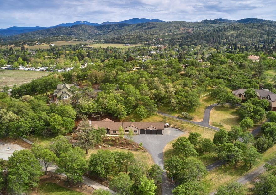 Outstanding single story, custom home surrounded by 2.58 acres in desirable West Hills neighborhood, close to Jacksonville with glorious views.  Privacy abounds with 3 bedrooms/2.5 baths, 3100sf of living space plus 800sf 4 bay garage.  An open floor plan welcomes you to contemporary beamed ceilings, laminate floors and the custom tiled wood burning fireplace with storage insert. The well-appointed kitchen has 18x18 tiled floors, a leathered marble island and honed marble countertops, facing the wet bar with wine cooler, wine rack.  Atrium doors allow access to the back patio. The light filled master bedroom has a sliding barn door to the bathroom where your soaking tub awaits.  Two guest bedrooms share a Jack and Jill bathroom.  Additional rooms include laundry/mud room, infrared sauna room and office/media room.  Fully fenced and drip irrigated, the back patio has a tranquil outdoor dining area with a natural rock water feature.  Seller is a licensed Oregon broker.