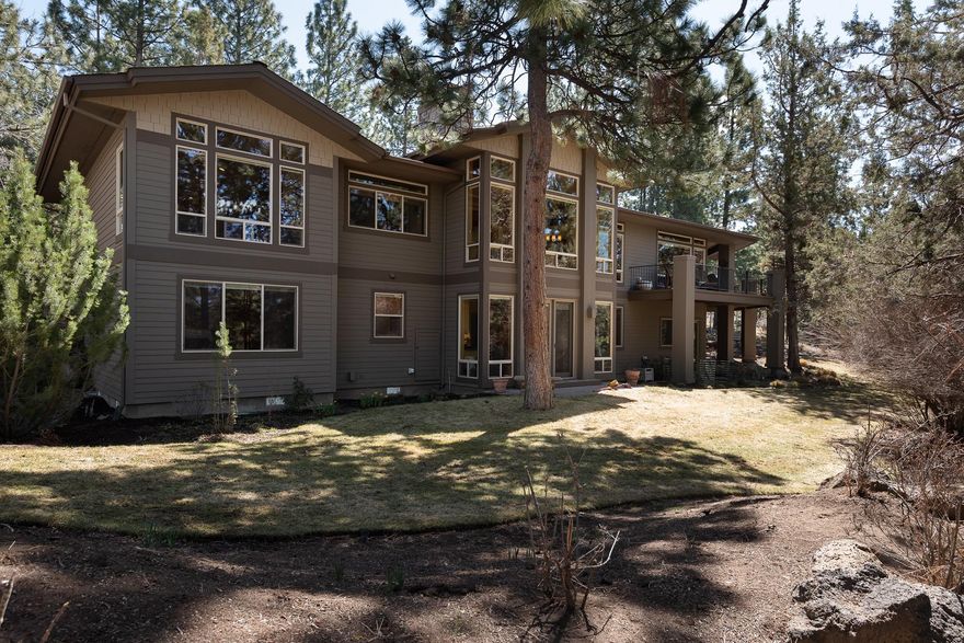 Step into luxury in this Bend, Oregon home in the desirable Awbrey Butte neighborhood. The quality is apparent in the beams, custom woodwork and walls of floor-to-ceiling windows, lending abundant, all-day light to nearly every room. The foyer opens up to a beautiful entertaining space and formal dining area. The great room features a chef's kitchen with Dacor double ovens and range; extensive granite counters, breakfast bar seating, built-in desk, casual dining and a family room. A covered, wrap-around deck extends the great room to the outdoors. Enjoy easy living with the  grand office and primary suite on the main floor, with a fun bonus room and 2 en suite bedrooms on the walk-out lower level. A flat, useable yard is a plus in this premier West-side location, along with the 3-car garage with a shop/ storage room. Built by premier builder Norman Building and Design. Live near West side trails, golf, restaurants, shops and schools - the best of all worlds!