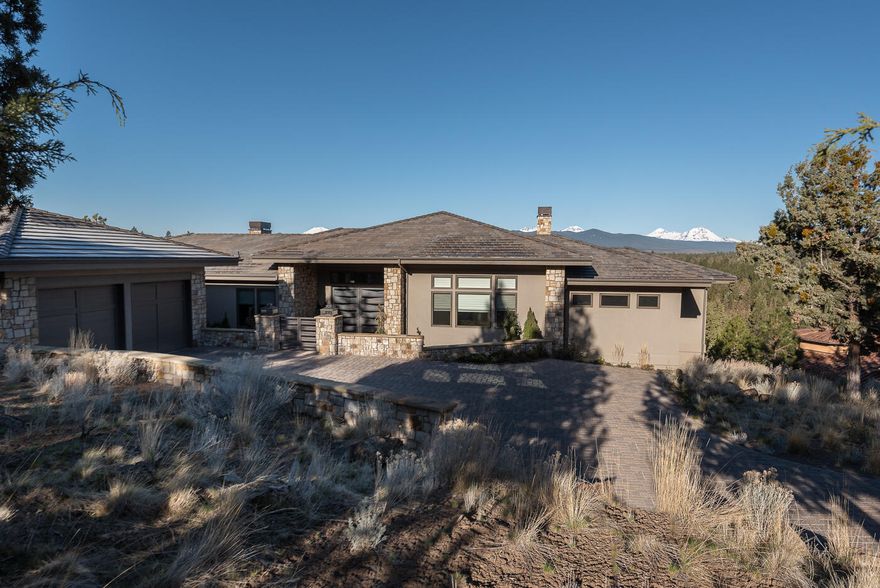 Stunning views from Mt. Bachelor to Mt. Hood. This exquisite modern style single level home has an open floor plan with large windows that capture the breath-taking mt. views. The living area features a beautiful low-profile fireplace with a large granite slab that complements the surrounding stone & floating shelves.  The master chef kitchen has top-of-the-line Miele appliances, solid granite waterfall edge island, custom built cabinets with all the newest storage design features you could ever dream of.  Just off the kitchen is the dining area with large sliding glass doors that enter out onto a large paver patio.  The main bedroom suite includes stunning views, gas fireplace, large walk-in shower, 2 vanities, soaking tub featuring a full wall of Carrara marble & mother of pearl. There is a large media room, additional 2 bedrooms with walk-in closets & full bath. Behind the oversized 2-car garage there is an art studio with sliding glass door leading to a private patio.