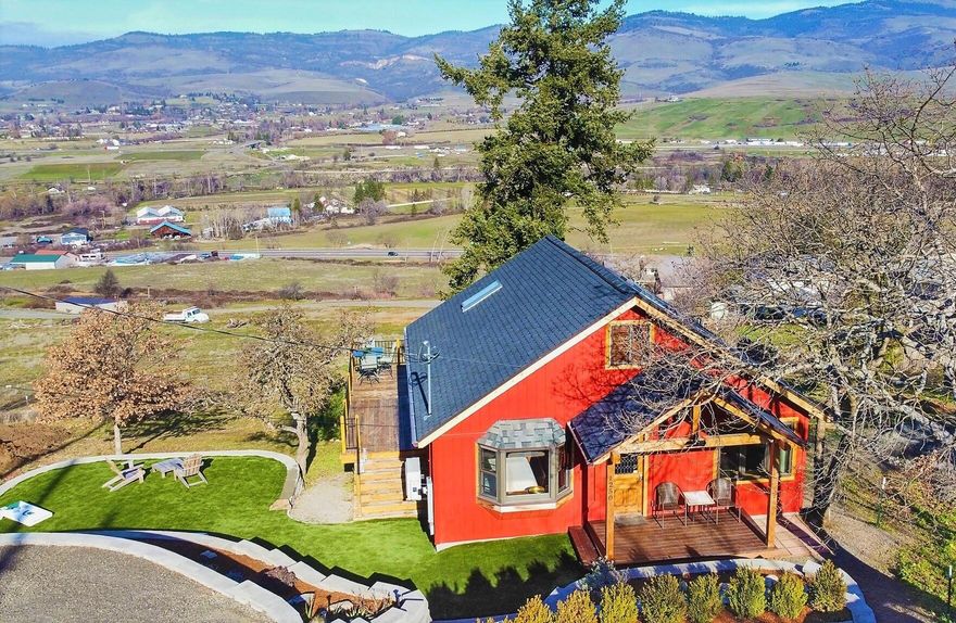 Unstoppable views!! Bright open great room living with vaulted ceilings and plenty of windows to absorb the view in this endearing Ashland cabin. Love and Character fills this home with smart space saving built-Ins, real hardwood floors and a kitchen garden window for happy plants. Conserve energy with the tankless water heater, Gas range,  ductless heating and air conditioning system and Brand-New Roof. One bedroom and full bath on the main level and a second bedroom with additional closet space under the eaves and office or reading loft up the circular staircase. Newly engineered landscaping provides off street parking, a terraced garden with drip irrigation and yard space ideal for gatherings. The oversized deck provides year-round additional living space while showcasing the unbeatable valley view. Don't miss the Workshop or Artist Studio, plus storage under the house. Close to the Ashland north exit for a quick commute into Medford and 1.5 miles to the plaza