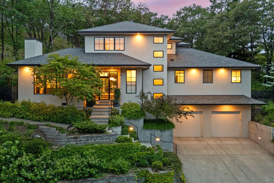 Timeless contemporary style and design. This stunning home is nestled into the hills above the boulevard in beautiful Ashland Oregon. 4 bedrooms, 3 1/2 baths w/approx. 3081 SF. Warm and inviting home w/ lots of natural light pouring in from the many windows, also capturing the picturesque treed setting that surrounds. Main level is up from the garage, perched above the street providing a nice sense of privacy. Light filled entry leads to a cozy living room w/ gas fireplace and spacious dining room w/ access to the lovely terraced backyard patio perfect for entertaining. White Oak engineered floors, tall 9 ft ceilings and 8 ft doors. Chef's kitchen w/Thermador appliances, quartz countertops, large center island and lots of cabinetry for storage. Primary bedroom suite w/ dual vanities, large shower and walk-in closet. Remaining bedrooms are upstairs, one en-suite and the other two share a full bath. This is an impressive property with a great location, close to a vast network of trails.