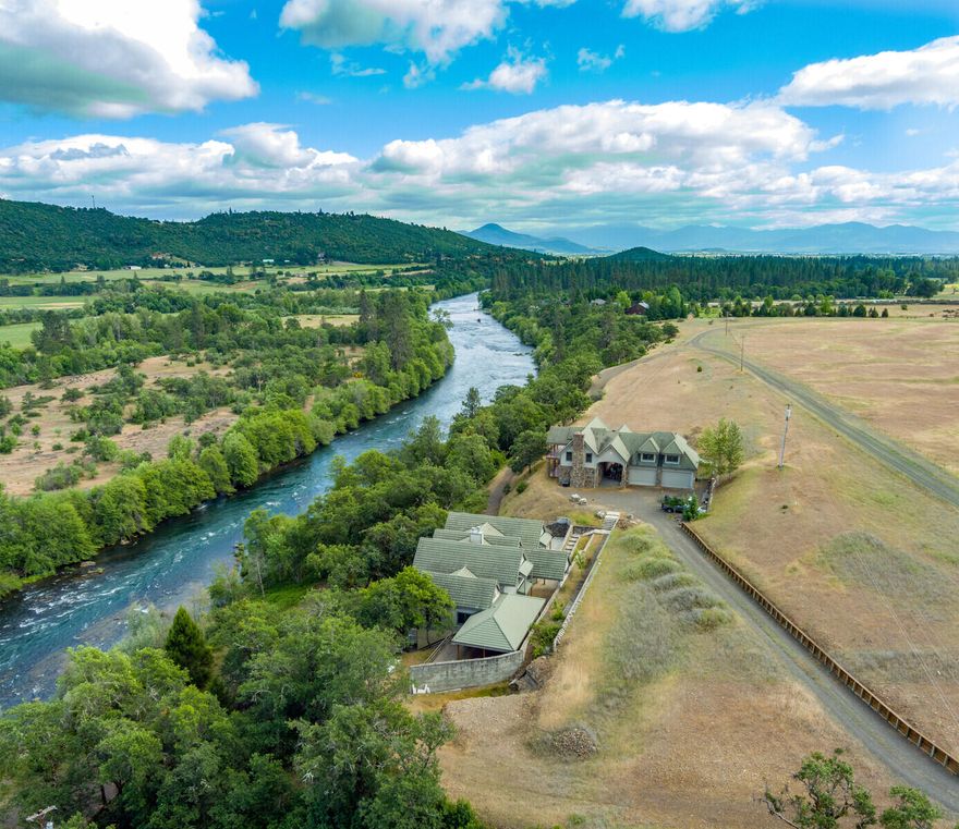 Stunning Rogue River front property with breathtaking views, 240 acres of EFU and OSR zoned land, 4 tax lots, and 1/4 mile of river frontage. The house was built by a seasoned European developer with a love for quality stone masonry and impeccable attention to detail: curved archways, generous windows, vaulted ceilings, maple and cherry floors, granite counters, abundant cherry cabinetry, limestone floors and a central stone fireplace made from imported Eastern European stone. The light-filled property offers a total of 5 bedrooms with river views, 2 home offices, 5 full and 2 half baths, as well as balconies. A driveway leads directly to the Rogue River with unobstructed access. This rare one-of-a-kind riverside sanctuary offers total privacy and immersion in nature. Tours are invited upon request.