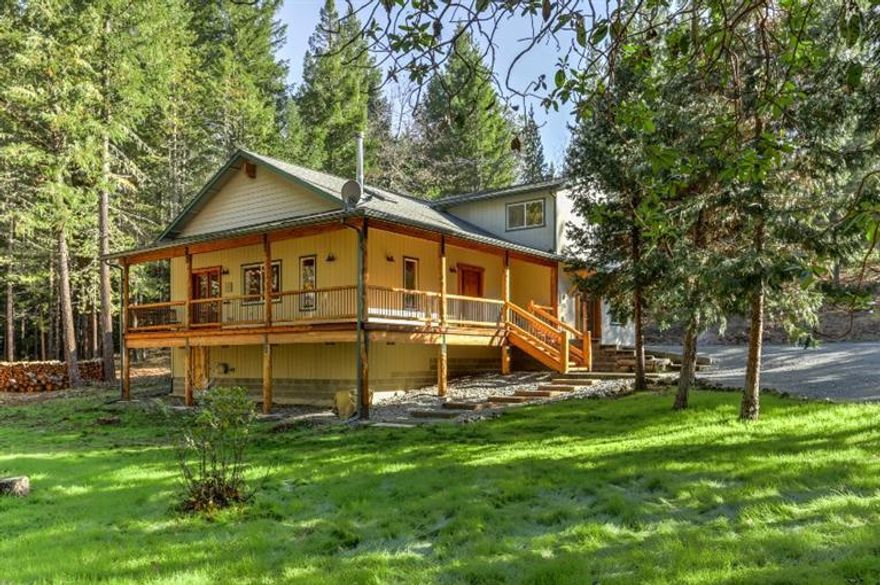 Fall in love with this tranquil, wooded setting and beautiful home nestled on 5.10 private acres.Built in 1998, this 2508 sf has 4 bedrooms, 3 baths, andlarge bonus room. A sun lit great room features a soaring, T&G sugar pine ceiling, skylights and free-standing wood stove with rock surround.Open kitchen has hickory cabinets and flooring, ample island and snack bar, large dining area with French doors leading to a fully covered, wraparound deck with sugar pine posts and rails.Retire from your day in the spacious master suite with walk-in closet and master bath with dual sinks. Bonus room could be spacious family room, game room or private living quarters with it's adjoining bedroom, walk-in closet and handicap accessible bath.Seasonal creek, nature trails, fenced garden area, new well pump, carport and room for RV parking.Fully fenced and gated, low taxes, property provides privacy and security just minutes from town. Check the virtual tour. Put this home on your must see list.