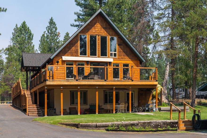 This rare waterfront property features a unique Chalet style home w/ high vaulted wood ceilings, tons of windows, huge wrap around deck w/ electric awning, & paved circular driveway that leads down to a detached 2 car garage w/ electric & heat, a carport and large backyard w/ private Deschutes River access perfect for kayaking or paddle boarding! Many upgrades including new log siding, composite roof (couple years old), walnut butcher block countertops in kitchen, kitchen appliances (3 years old), vinyl plank flooring & storm doors throughout. This home features a finished basement with a bonus room and a 2 bed/1 bath apartment with a kitchen, private entrance and patio to the backyard - perfect for a vacation or long-term rental! Main floor features a great room w/ doors out to the deck, good sized bedroom, full bath & laundry/mud room with a shower. Upstairs is a loft and primary suite w/ 7 closets, jet tub, full bathroom, and lots of charm. Neighborhood has private marina