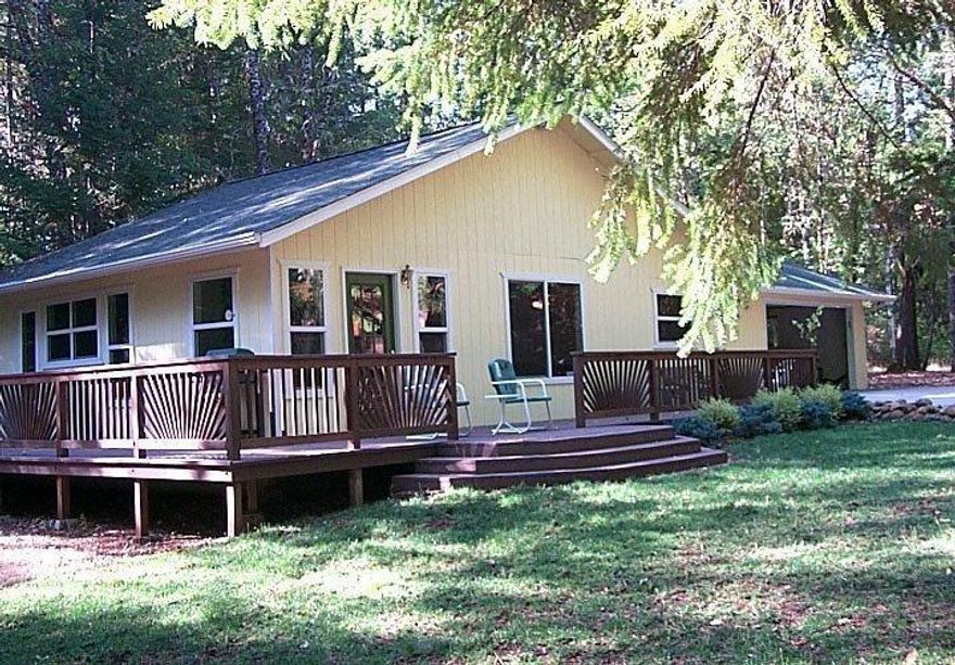 Talk about a diamond in the woods! This home was totally remodeled in 2004 with a new roof, added oversized - finished garage, deck around 2+ sides of the home, laminate floors, all new appliances, cabinets in kitchen, heat pump, attic fan, wood burning stove, 3 ceiling fans, new fixtures & cabinets in the bathroom, washer, dryer & water heater. There is lots of ways to expand this home and plenty of room to do it. There is a large list of personal items being sold with the home. Several outbuildings that includes an office, shop, storage with a guest bedroom above the shop. Well house has large concrete in ground holding tank. The well was drilled in 2005 & 4 hour flow test produced average of 4.6GPM. The property is level & private with lots of trees. Front yard is grass with sprinkler system installed. Now all it needs is a new owner. Oh, don't forget about the RV hook-up & dump station.