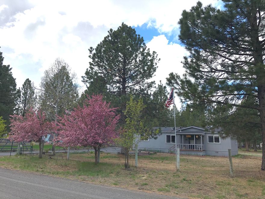 Take a look at this Original Owner Occupied Home with Beautiful Crab Apple Trees, a Burnt Red Maple, Aspens and Tulips.
Extremely Well maintained 3 Bedroom 2 Bath on an acre.  Home features a Paved driveway, a fully fenced and gated yard, and Two Wells, a New one for the Home and an older one for Irrigation.  A Two year old 25 year Roof and Skylight,  Exterior Paint just done Four years ago, and a Five Year old Heat Pump with A/C.  The Exterior Has an oversized Two Car Garage, an additional Storage Building as well as a Larger Storage Building for your Boat and RV.  Enjoy your Back Yard with a large cover back deck with Removable Panels to Protect in the Colder months.