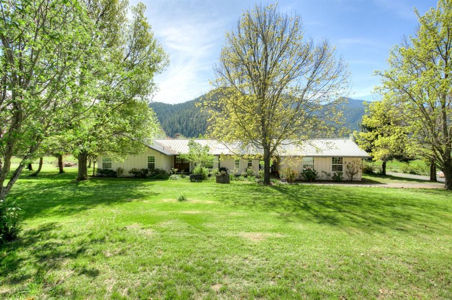 Space to grow! Enjoy rural living at its best in this comfortable single level ranch home on almost ten flat acres with full irrigation rights. Just minutes from Jacksonville, this spacious home features a vaulted ceiling through the kitchen, dining, and living area, wonderful deck with stunning views of the property and surrounding hills. Three bedrooms, three baths, and a bonus den provide ample space. With a huge two car garage, separate 40x80 shop (easy conversion to a barn), and covered area for two RV's (including electrical, water, sewer, internet, satellite), there is room for all your toys, tools, and haulers. The ten acre property is completely fenced, with a very slight southern slope making for ideal growing conditions. Property enjoys ancient water rights from a private ditch off the Applegate river. Mature orchard with apple, cherry, and pear trees. Country living, low taxes, relaxed lifestyle.