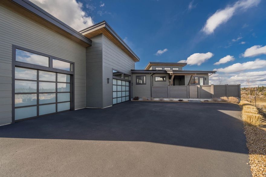 Tucked into a private corner on the Tetherow Golf Course, this spectacular contemporary estate offers a mountainview retreat like no other. Take in Mt. Jefferson, the Three Sisters, and Broken Top from the vaulted great room, or open the sliding doors to the covered, heated deck to bring the outdoors in. The
great room offers a 72'' electric fireplace w/ heater for cold nights or ambience. Entertain guests from your well-appointed kitchen, featuring GE Monogram/Cafe appliances & a large breakfast bar, or serve drinks from the nearby dry bar. In the main-level owner's suite, enjoy mountain views through floor-to-ceiling windows. A luxurious owner's bath offers a curbless tile shower and double vanity. Also on the main level, find two offices as well as a large mud/laundry room
off the 3-car garage. Downstairs, a fully equipped media room includes a screen, theater seating, & A/V equipment. Two BDs & two full baths are also on this level, plus patio w/ spa & water feature off media room.