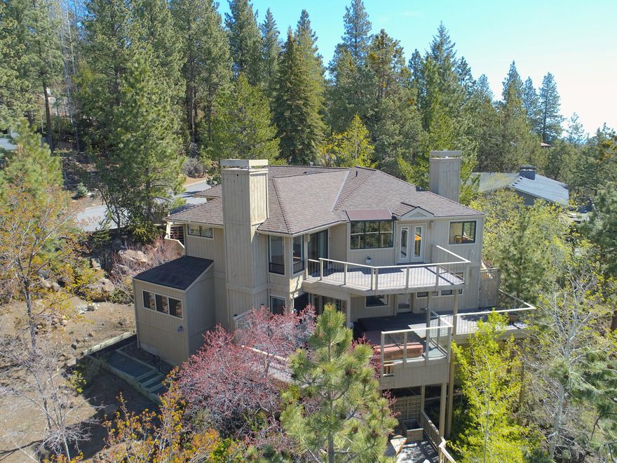 With views from the Old Mill Smokestacks to the Cascade Mountain Range you'll be living with some of the nicest views in Bend!  There is so much room here both inside and outside you can spread out in the summertime, or cozy up by one of the 3 fireplaces in the winter. Three outside decks including one with a hot tub give you plenty of space to enjoy the outdoors.  You will also love the views from inside seeing the mountains from the kitchen, and living areas!  This house can live as a 3 bedroom with a bonus room with wet bar, or as a 4 bedroom home.  Through the master suite is an office.  The garage has a door to the heated workshop.  Don't miss the large unfinished space underneath the home, not included in the square footage, currently used to hit golf balls, but can be many other things!