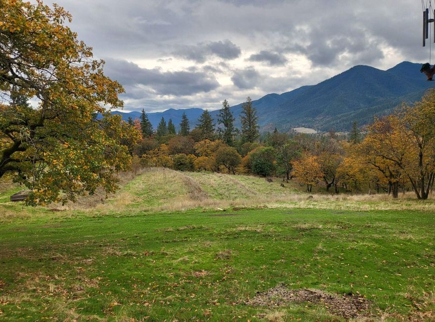 What and amazing view of the valley and surrounding mountains, with lots of sun and an open sky. No HOA's or CC&R's. Manufactured home in very good condition, with front porch and Metal Carport. The home is a 1971 Single-wide, and it is in very good condition. 10 minutes to downtown Jacksonville and 20 minutes to Murphy. Excellent privacy and lots of trees in this location, build your new home, while living onsite.