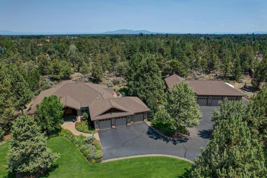 Over two beautifully manicured acres just outside Bend city limits! Located near the Old Deschutes neighborhood, this home is only a short distance from Pine Nursery Park and the medical corridor. This single level mountain home is perfectly paired with a spectacular RV/shop, ideal for a car collector or someone that loves their toys. Schumacher Construction raised the bar on this beauty! Known for their quality in materials and craftsmanship, this dramatic home has a warm, rustic elegance with all the luxurious touches you would expect in a custom home. Alder custom cabinetry, distressed hickory floors, alder wrapped windows and 8 ft wood doors. The vaulted great room with exposed beams and massive fireplace is perfect for entertaining; and the open kitchen with gorgeous granite sitting bar will make the most experienced chef jealous. Wonderfully balanced landscaping with private paver patio combined with a natural rock waterfall, fire pit and pond make this a true backyard retreat.